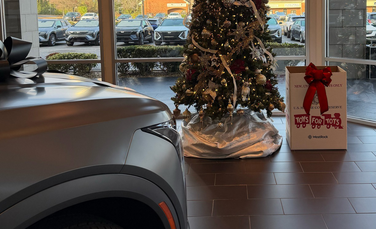 toys for tots box next to Christmas tree in dealership