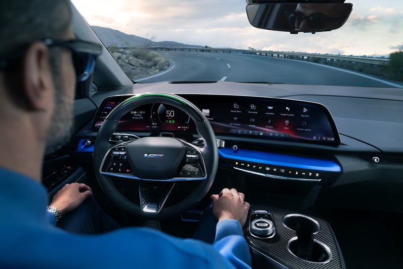 Front View of the 2026 OPTIQ-V Driving Through the Dusk Utilizing its Headlights | Heritage Cadillac in Morrow GA